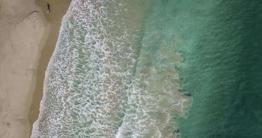 luchtfoto vliegen over mediterraan strand met één persoon lopend video