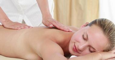 Masseuse massaging her client back