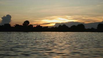 kleine boot tijdens een rit op een meer bij zonsondergang