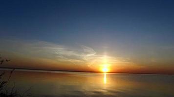 marchant le long de la rive d'un grand lac. beau coucher de soleil sur le lac. video