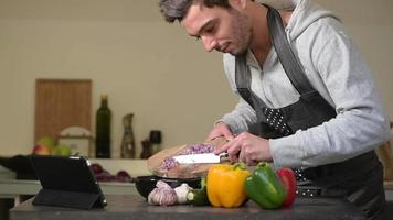 jonge man koken in de keuken thuis met tablet