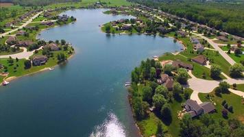 suburbio rural próspero en el hermoso lago artificial, vista aérea. video