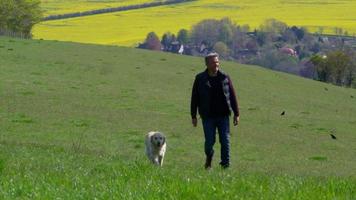 Hombre maduro lleva perro a pasear en el campo filmado en r3d