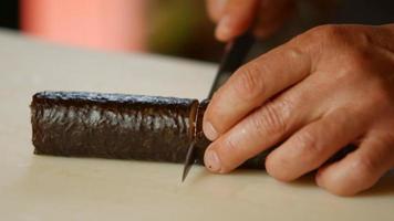 Hands with knife cut sushi. video