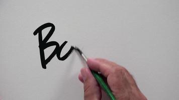 mão humana escrevendo "boom" com tinta preta video