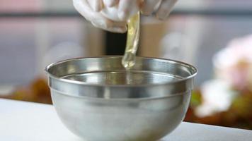 Raw egg pours into bowl.