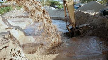 descarga de tubería de arena de río dragada al sitio de disposición y excavadora en uso