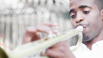 svart man spelar en trumpet på gatan