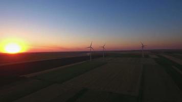 Vue aérienne de grandes éoliennes dans un parc éolien au coucher du soleil