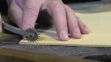 Artesano de artículos de cuero en el trabajo en su taller. video