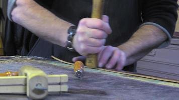 Artesano de artículos de cuero en el trabajo en su taller. video