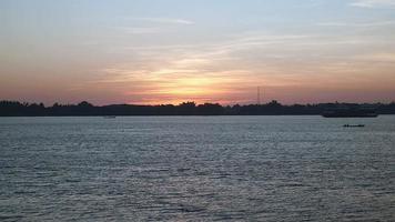 vista à distância de um navio de cruzeiro no rio após decolar ao nascer do sol