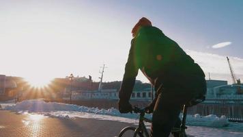 cara andando de bicicleta com engrenagem fixa na estação marítima, 4k video