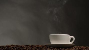 xícara de café com vapor. fundo escuro com grãos de café