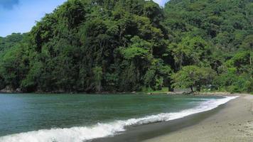 Scenic view of beach with green mountain, Trinidad, Trinidad and Tobago