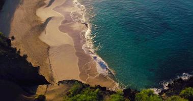 Vol aérien 4k sur la plage de sable blanc et le magnifique océan bleu. incroyable lever de soleil sur un paysage tropical. video