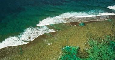 vista aérea volando sobre el arrecife del océano y las olas