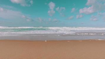 onde dell'oceano in arrivo sulla spiaggia di sabbia