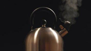 Steam from a steel kettle. Black background video