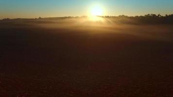 Lever de soleil surréaliste sur paysage rural brumeux pittoresque, survol aérien