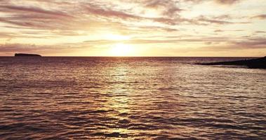 Luftaufnahme, die über ruhigem Ozean in schönen Sonnenuntergang fliegt video