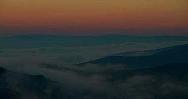 bella alba all'alba del vertice sopra le onde nebbiose nebbiose fluenti in montagna, lasso di tempo in hdr