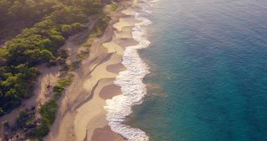 Vol aérien 4k sur la plage de sable blanc et le magnifique océan bleu. incroyable lever de soleil sur un paysage tropical. video