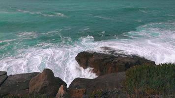 havsvågor som bryter på sten