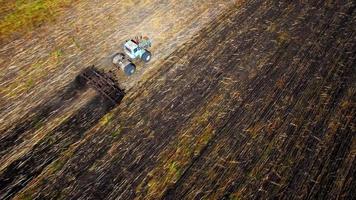 Flygfoto över traktorn som plöjer jorden