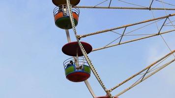 panorering skott av pariserhjul på nöjespark med blå himmel