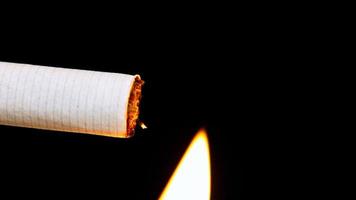 Makroansicht der brennenden Zigarette mit Rauch auf Schwarz video