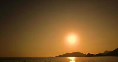 Sun setting over coastal headland video