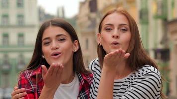 Two women blow a kiss and laugh video