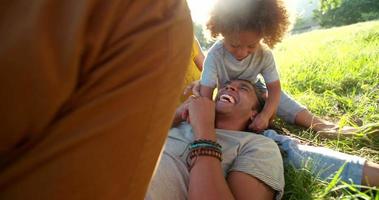 atemberaubende afroamerikanische Familie, die sich miteinander entspannt, während sie glücklich lacht