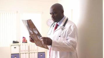 médico afro-americano revisando exames video