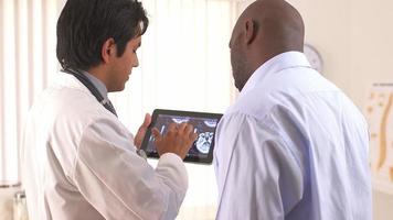 medico ispanico utilizzando tablet pc per condividere la risonanza magnetica con il paziente video