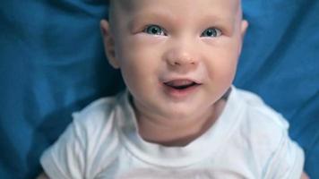 adorable bebé en dormitorio soleado azul. niño recién nacido relajándose en la cama. guardería para niños pequeños.  video