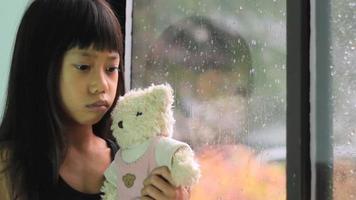 asiatisk tjej tröstad av nallebjörn