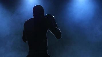 bokser toont training voor het gevecht. silhouet op donkere achtergrond