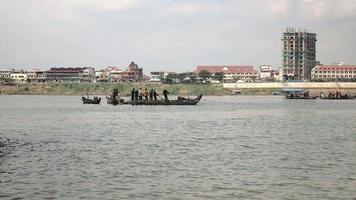 pescadores em barcos levantando uma grande rede da água