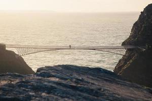 People walking on a bridge at golden hour photo