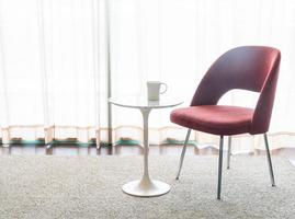 silla roja y mesa con una taza de café foto
