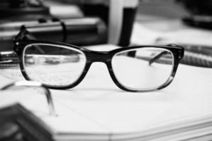 Close-up of glasses on a stack of papers