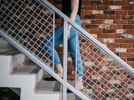 Mujer caminando por las escaleras cerca de la barandilla y la pared foto