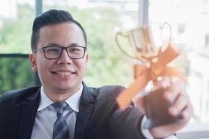 hombre de negocios con un trofeo foto