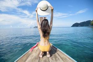 Woman holding hat on a boat photo