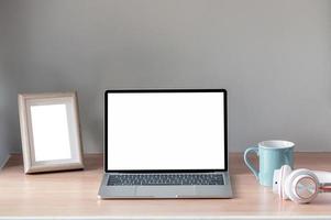 Laptop and picture frame mockup on a table photo