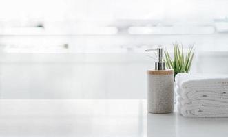 Soap dispenser and towels on a table photo