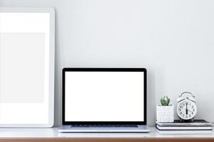 Laptop and picture frame mockup on a desk photo