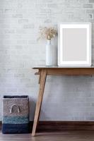 Picture frame mockup with flowers on wooden table